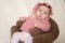 Sweet portrait of adorable mixed ethnicity Asian Caucasian baby girl a few weeks old sitting on mini sofa couch wearing a sweet