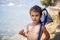 Sweet portrait of a boy, eating donut on the beach