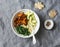 Sweet potato, couscous, spinach, avocado buddha bowl on grey background, top view. Vegetarian comfort food