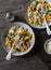 Sweet potato and pork sausage soup with spinach and pasta on a dark background, top view. Delicious autumn, winter comfort food