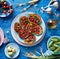 Sweet potato toast with beet hummus, grilled chickpeas, fresh parsley, nigella seeds and sunflower seeds on a plate on a blue ta