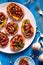 Sweet potato toast with beet hummus, grilled chickpeas, fresh parsley, nigella seeds and sunflower seeds on a plate on a table