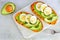 Sweet potato toasts with avocado, eggs and chia seeds flat lay on a bright background.