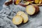 Sweet potato tuber and round slices of raw yam on rough burlap gray napkin and potato peel on background. food content, atmosphere