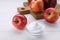 Sweet powdered fructose and fresh apples on white wooden table