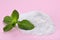 Sweet powdered fructose and mint leaves on pink background