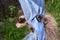 A sweet racoon - baby hangs on jeans, looks aside