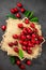 Sweet red cherry on burlap on a black background. A large number of cherries with leaves on the table, on a black