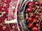 Sweet ripe cherries in a metal plate on a glass table.