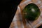 Sweet ripe green striped watermelon on kitchen towel, black background. Organic seasonal farm fruits. Healthy vegan food