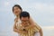 Sweet and romantic lifestyle portrait of young happy Asian Chinese couple in love enjoying holiday or weekend with man carrying