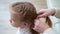 A sweet school girl yawns while mother braids hair. early rises to school.