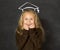 Sweet schoolgirl on blackboard with with chalk sketch drawing of graduation hat smiling happy