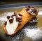 Sweet sicilian cannolo stuffed with ricotta cheese cream and cho