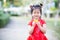 Sweet smile 4 year old kid girl wearing red cheongsam. Child holding gold ingot. Empty space to enter text. Happy Chinese New Year