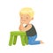 Sweet smiling little boy sitting on the floor leaning on a small green stool, colorful character