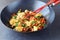 Sweet and sour beef stir fried in the wok with cauliflower and vegetables on a grey abstract background. Oriental dish