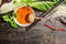 Sweet-sour sauce with Shiitake mushrooms, pak choi and chopsticks on rustic background, top view.