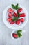 Sweet strawberry and green leafs on the white china dishes