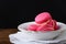 Sweet strawberry macaroon in a plate on dark background