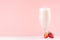 Sweet strawberry milkshake in exquisite wineglass decorated slices berry on light pastel pink background.