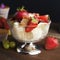 Sweet summer dessert. Ice cream in glass bowl with fresh strawberries, fruits and muffins. Wooden table, black background. Close u