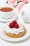 sweet tartlet with meringue and raspberry, vertical top view
