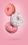 Sweet tasty donuts falling on pink background