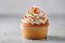 Sweet tasty vanilla cupcake whipped cream sprinkles topping pastry with wrapped festive Birthday present gift box orange