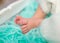 Sweet tiny newborn feet on furry turquoise blanket, closeup