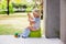 Sweet toddler boy, sitting on potty on a back porch in a holiday resort patio