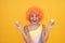 sweet tooth. funny kid in clown wig hold french macaron. amazed child wear swimsuit.