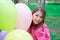 sweet tween brunette girl in pink holding colorful balloons outdoors. party, birthday concept. summertime. happy kids