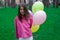 sweet tween brunette girl in pink holding colorful balloons outdoors. party, birthday concept. summertime. happy kids