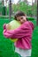 sweet tween brunette girl in pink holding yellow balloon outdoors