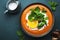 Sweet vegan pumpkin soup with coconut cream, orange and mint. Winter or autumn healthy vegetarian comfort food. Soup bowl on green