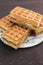 Sweet Viennese waffles with white filling lie on a saucer