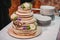 Sweet wedding cake with tiers decorated with flowers on white table