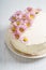 Sweet white buttercream cake with pink flowers on top