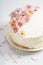 Sweet white buttercream cake with pink flowers on top