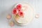 Sweet white buttercream cake with pink rose flowers on top