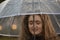 Sweet young girl with lush brown hair under transparent umbrella. Seasonal autumn portrait