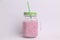 Sweet and yummy strawberry smoothie in the glass jar with a straw