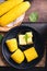 Sweetcorn cob and butter on black plate