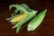 Sweetcorn Cobs on a Polished Wooden Table Top Closeup View