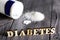 Sweetener tablet and sugar. Text diabetes wooden letters.