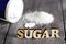 Sweetener tablet and sugar. Text sugar wooden letters.