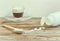 Sweetener in tablets in wooden spoon on table, white jar with sweetener, cup of cappuccino coffee