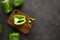 Sweetn green peppers on wooden cutting board on black and dark grey background. Green pepper sliced and chopped on wooden chopping