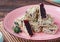 Sweetness, square marmalade beet candy in sesame sprinkling on a pink plate on a brown wooden background. Korean cuisine